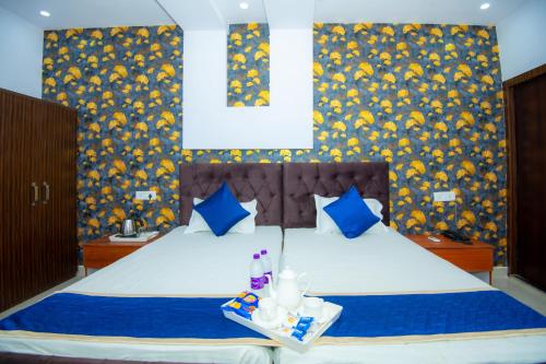 a bedroom with a bed with blue and yellow wallpaper at Hotel Blossom in Lucknow