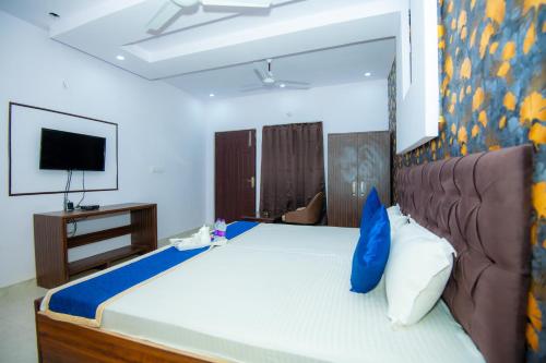 ein Schlafzimmer mit einem großen Bett und einem TV in der Unterkunft Hotel Blossom in Lucknow