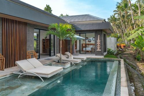 una piscina con tumbonas y una casa en Villa Surga - 4BR Heavenly Ricefields View Villa in Ubud en Ubud