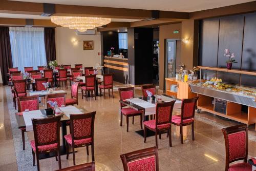 a restaurant with tables and chairs and a buffet at Hotel Regal in Braşov
