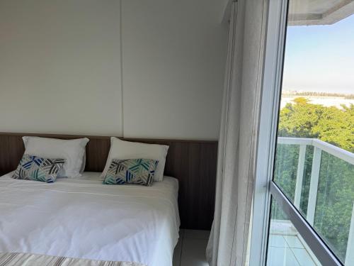 a bedroom with a bed and a large window at RioStay suíte com varanda ao lado do Riocentro Farmasi Arena Parque Olímpico Globo Projac in Rio de Janeiro