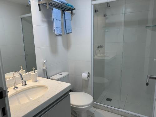 a bathroom with a toilet and a sink and a shower at RioStay suíte com varanda ao lado do Riocentro Farmasi Arena Parque Olímpico Globo Projac in Rio de Janeiro