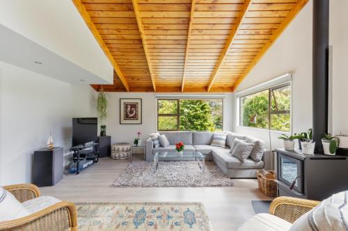 a living room with a couch and a table at Palm Beach Waiheke Tranquil B&B in Ostend