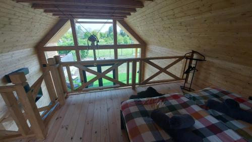 ein Schlafzimmer mit einem Bett und einem Fenster in einer Hütte in der Unterkunft Z-Woods in Maklár