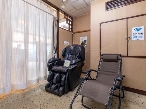 a waiting room with a chair and a barber shop at Asahi sauna Capsule Inn Hirosaki in Hirosaki