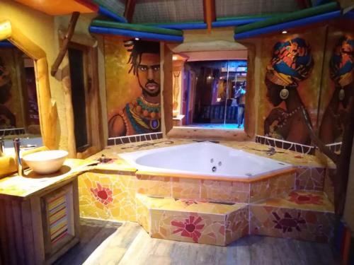 Hotel Boutique El Duende Mantagua في كوينتيرو: حمام مع حوض مع لوحة على الحائط