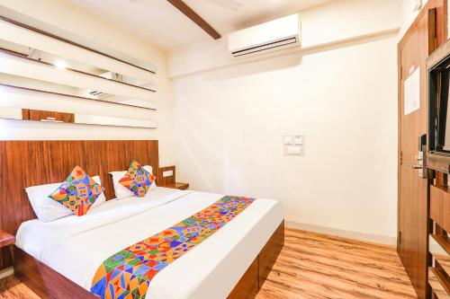 sypialnia z dużym łóżkiem z kolorowymi poduszkami w obiekcie FabHotel Arastu w mieście Hajdarabad