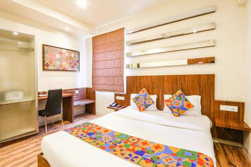 ハイデラバードにあるFabHotel Arastuのベッドとデスクが備わるホテルルームです。
