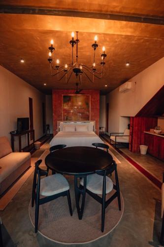 a bedroom with a bed and a table and a chandelier at The Villa Lakeshore in Anuradhapura