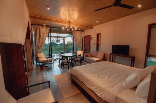 a bedroom with a bed and a table and chairs at The Villa Lakeshore in Anuradhapura