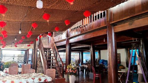 un restaurant avec des coeurs en papier rouge suspendus au plafond dans l'établissement nhà gỗ homestay nguyên văn, à Hưng Lương