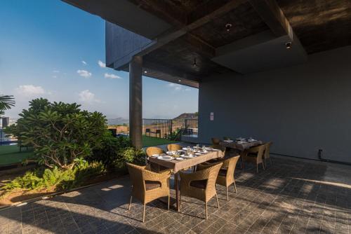 ein Esszimmer mit einem Tisch und Stühlen auf einer Terrasse in der Unterkunft Wabi Sabi Resort, Igatpuri in Igatpuri