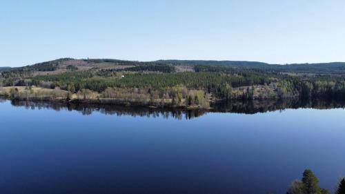 a view of a large lake with trees on a hill at Ferienhaus am See (Rådasjön) in Råda