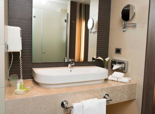 a bathroom with a white sink and a mirror at Holiday Inn Santiago - Airport Terminal by IHG in Santiago