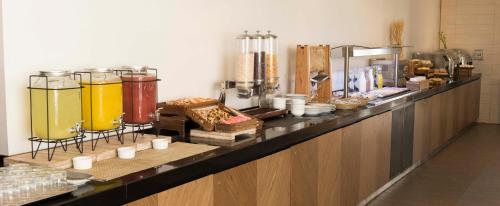 a counter with a bunch of different types of food at Holiday Inn Santiago - Airport Terminal by IHG in Santiago