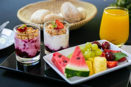 a tray with two desserts and a plate of fruit at Holiday Inn Santiago - Airport Terminal by IHG in Santiago