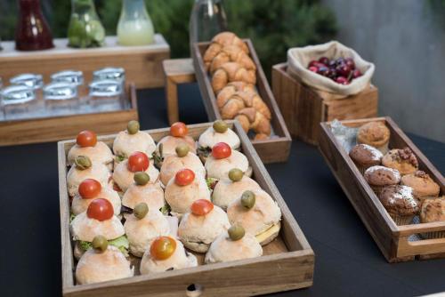 a table with trays of pastries and other foods at Holiday Inn Santiago - Airport Terminal by IHG in Santiago