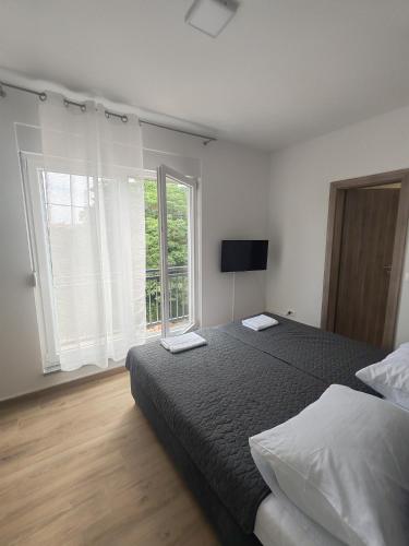 a bedroom with a bed and a large window at Adriatica in Zadar