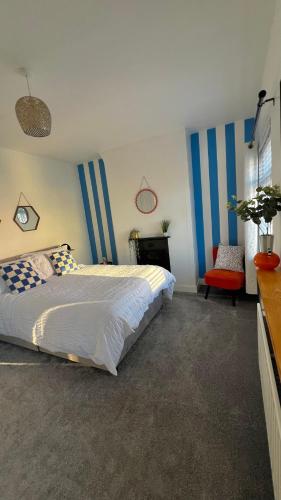 Schlafzimmer mit einem Bett mit blauen und weißen Streifen in der Unterkunft Honeymoon Row in Pennyburn