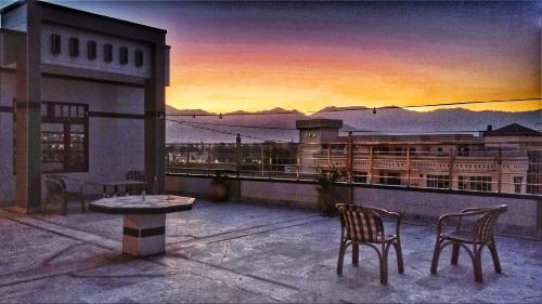 a patio with two chairs and a table on a balcony at Hotel Swat Rezidor by Khan Familia Travels in Swat