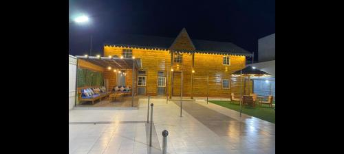 a wooden building with a patio at night at القصر الريفي in Al Khafji