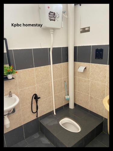 y baño con aseo y lavamanos. en Kpbc Homestay 3bilik, en Jitra
