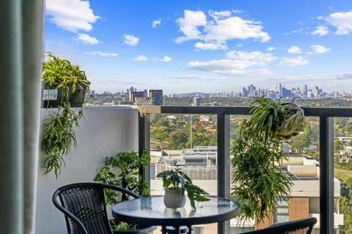 a balcony with a table and chairs and a view of the city at High level urban retreat in Macquarie Park in Sydney
