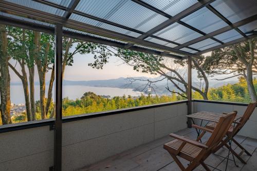 a chair on a porch with a view of a lake at kamenos Luxury Resort With Beautiful Scenery Hiji in Hiji