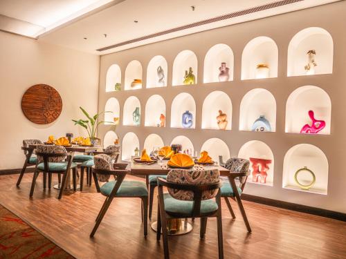 a dining room with a table and chairs at Novotel Kolkata Hotel and Residences in Kolkata