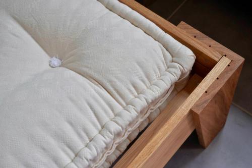 a close up of a mattress on a wooden bed frame at Le Concept-Studio in Perrigny-sur-Armançon