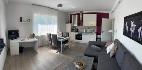 un soggiorno con un divano, un tavolo e una cucina di Ferienwohnung Schlossblick - 4 Sterne Sauna Pool Whirlpool exklusiv a Braunfels