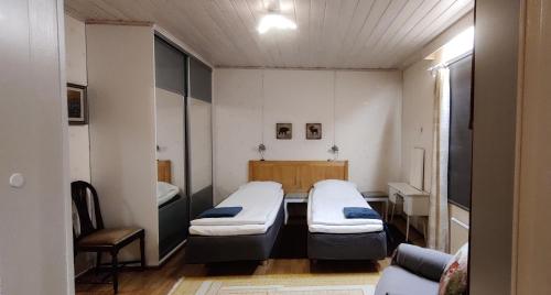 Cette chambre comprend 2 lits et une chaise. dans l'établissement Vacation House Kommee Kurki, à Sastamala