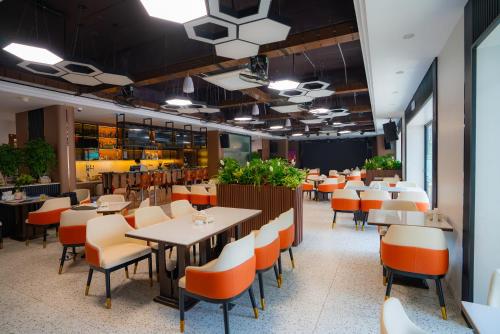 restauracja ze stołami i krzesłami w kawiarni w obiekcie Capital Garden Hotel w mieście Hanoi