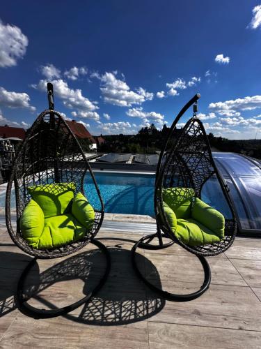 dwa krzesła z zielonymi poduszkami siedzącymi obok basenu w obiekcie Ferienwohnung Schlossblick - 4 Sterne Sauna Pool Whirlpool privat w mieście Braunfels