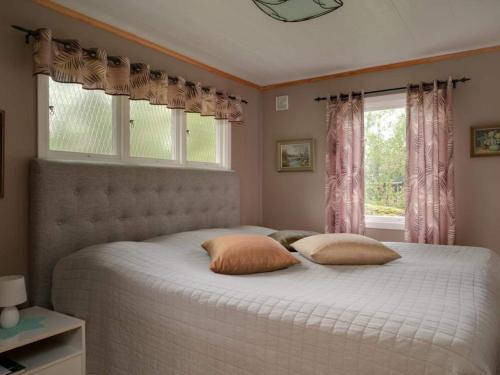 a bedroom with a bed with two pillows and two windows at 4 star holiday home in Sparreholm in Sparreholm