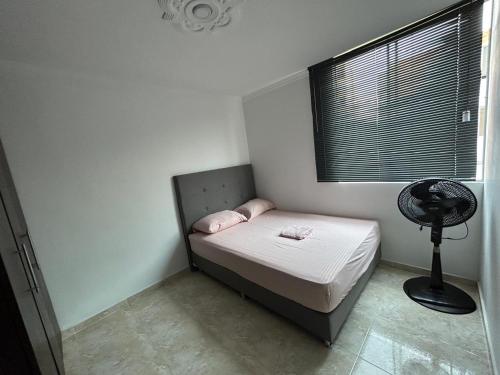 ein kleines Schlafzimmer mit einem Bett und einem Ventilator in der Unterkunft Bello apartamento de 3 habitaciones in Cúcuta