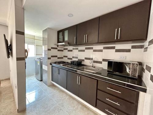 a kitchen with a sink and a microwave at Bello apartamento de 3 habitaciones in Cúcuta