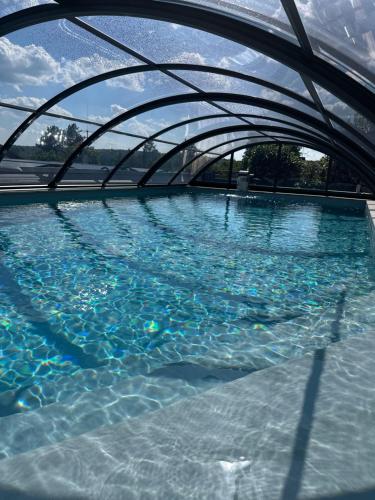 uma piscina de água com uma ponte sobre ela em Ferienwohnung Schlossblick - 4 Sterne Sauna Pool Whirlpool privat em Braunfels