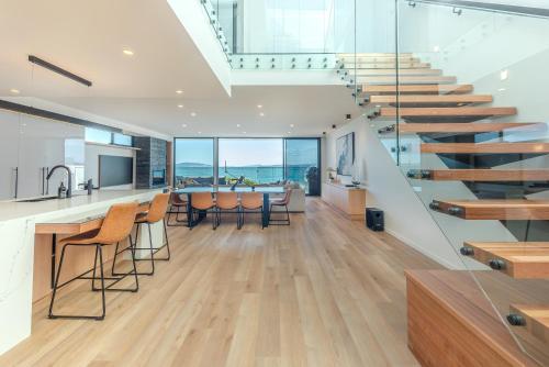 a kitchen and dining room with a staircase in a house at Award-winning beachfront luxury in Cremorne in Sandford