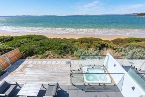 a view of the beach from the balcony of a house at Award-winning beachfront luxury in Cremorne in Sandford