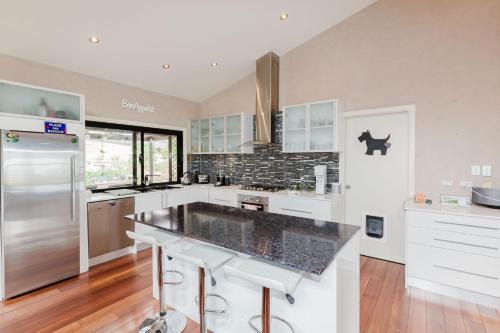 a kitchen with white cabinets and a black counter top at 10 Kanangra House - 1-10 Kanangra Crescent in Jindabyne