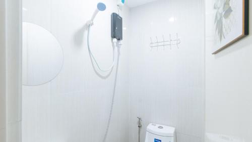 a white bathroom with a shower and a toilet at RedDoorz @ Aerial Hotel Los Baños in Los Baños