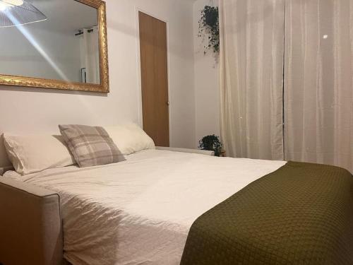 une chambre avec un lit avec un miroir au mur dans l'établissement Cosy - Magnifique vue sur parc Georges Brassens, à Paris