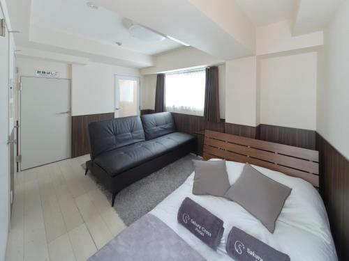 a bedroom with a bed and a couch in it at Sakura Cross Hotel Ueno Iriya in Tokyo