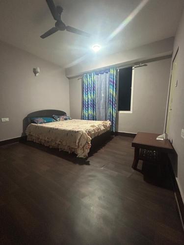 sypialnia z łóżkiem i wentylatorem sufitowym w obiekcie Pearl Nest Homestay w mieście Martam