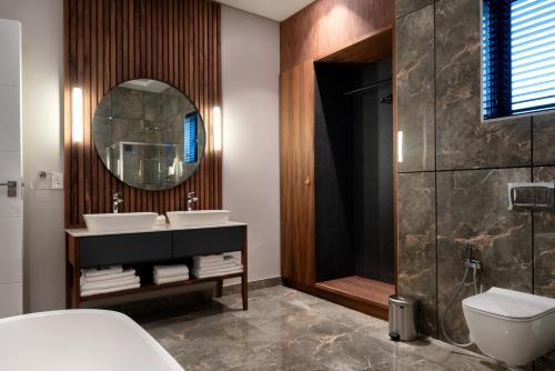 a bathroom with two sinks and a mirror at Anfani Boutique Hotel in Humewood