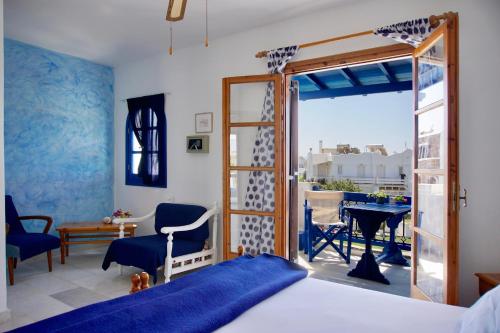 a bedroom with a bed and a balcony with a table at fi naxos in Agios Prokopios