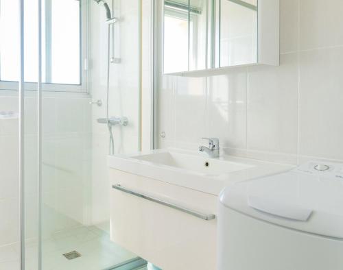 a white bathroom with a sink and a shower at Appartement une chambre avec vue sur la baie des Sables 4 personnes in Les Sables-dʼOlonne