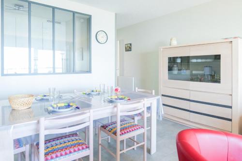 une salle à manger avec une table et des chaises blanches dans l'établissement Appartement une chambre avec vue sur la baie des Sables 4 personnes, à Les Sables-dʼOlonne