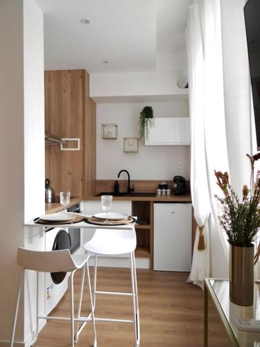 une cuisine avec une table et des chaises dans une pièce dans l'établissement Le Blum Studio *Hyper-Centre* avec *CANAL PLUS*, à Amiens